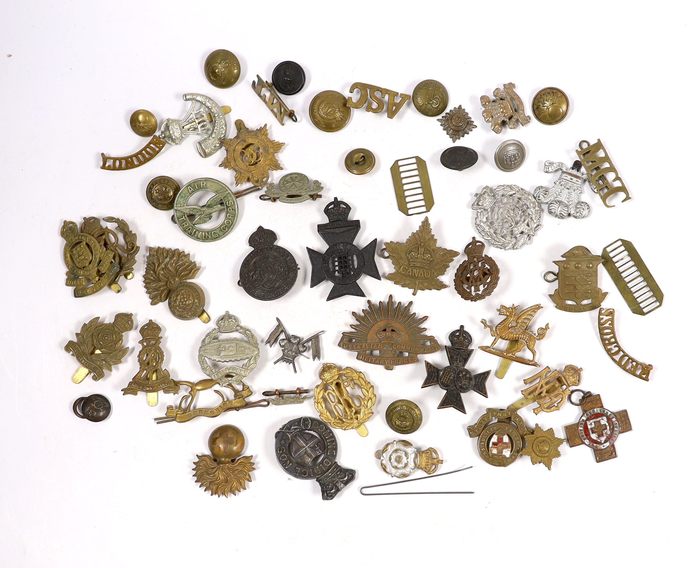 Twenty-five military cap badges including Air Training Corps, Australian Commonwealth Military Forces, Royal Army Ordinance Corps, Royal Engineers, Intelligence Corps, Royal Army Service Corps, RFC, etc. Together with a